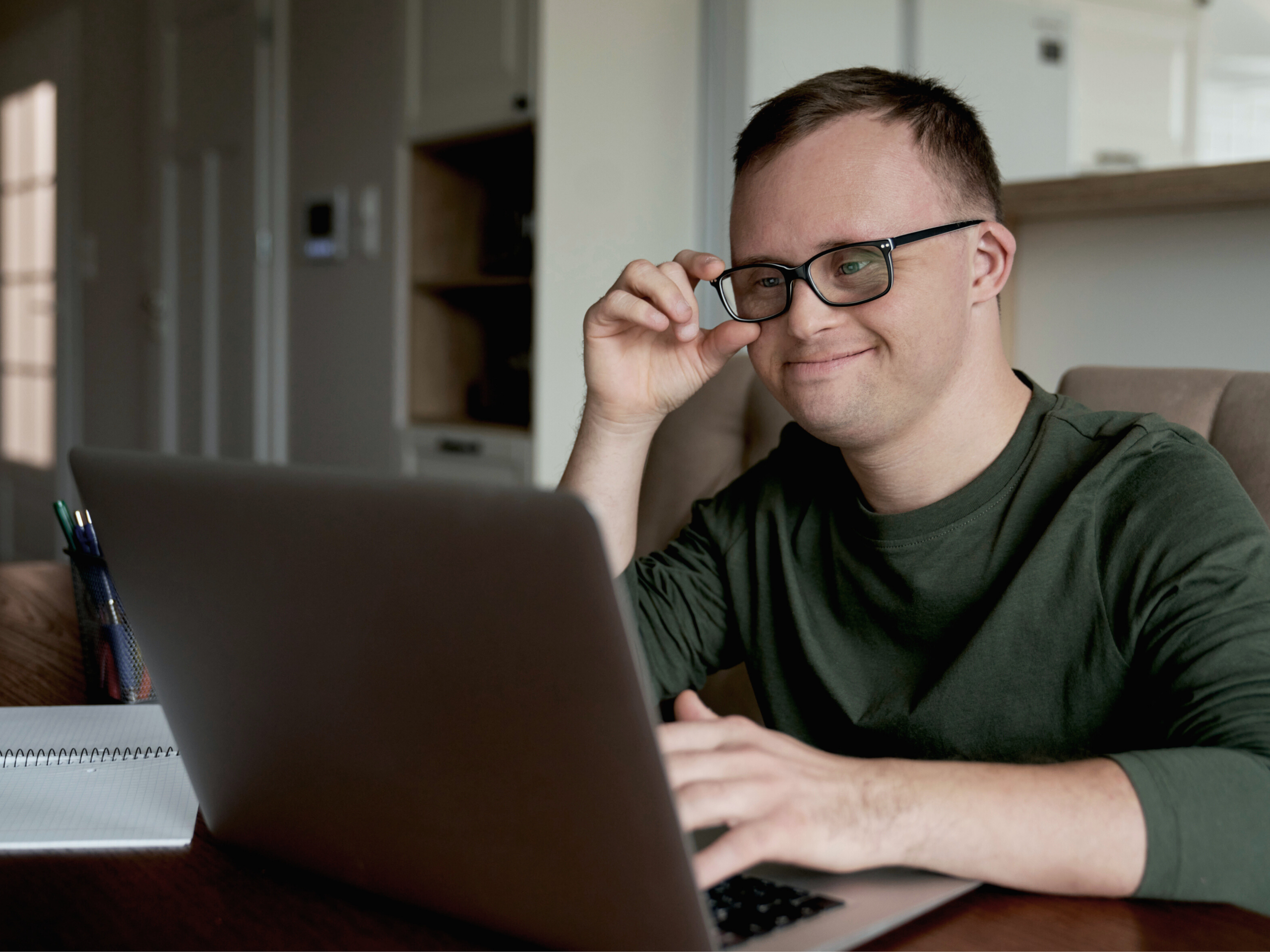 Eine Person mit Downsyndrom sitzt am PC