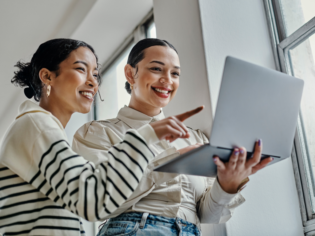 Zwei Frauen schauen auf einen Laptop