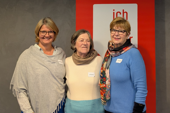 Auf dem Foto sind drei Frauen zusehen, die in die Kamera lächeln.